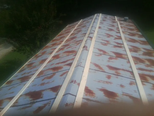 Rusted metal roof panels with new wood purlins before replacement — Storm Damage Roof Repair in New Enterprise by Roofing Brothers
