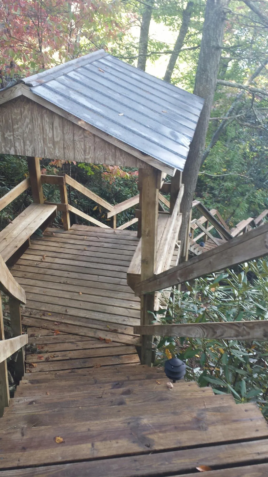 Metal roofed shelter over wooden steps on a wooded walkway — Skylight Repair & Installation work by our crew in New Enterprise