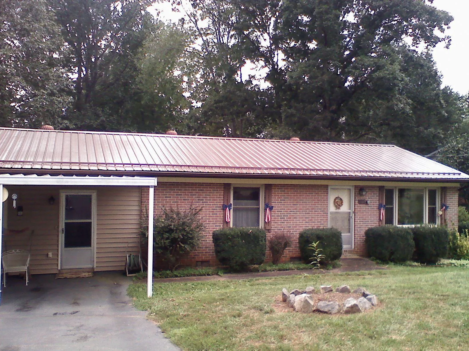 Bronze metal roof and carport on a brick ranch home — Roof Repair work by our crew in New Enterprise