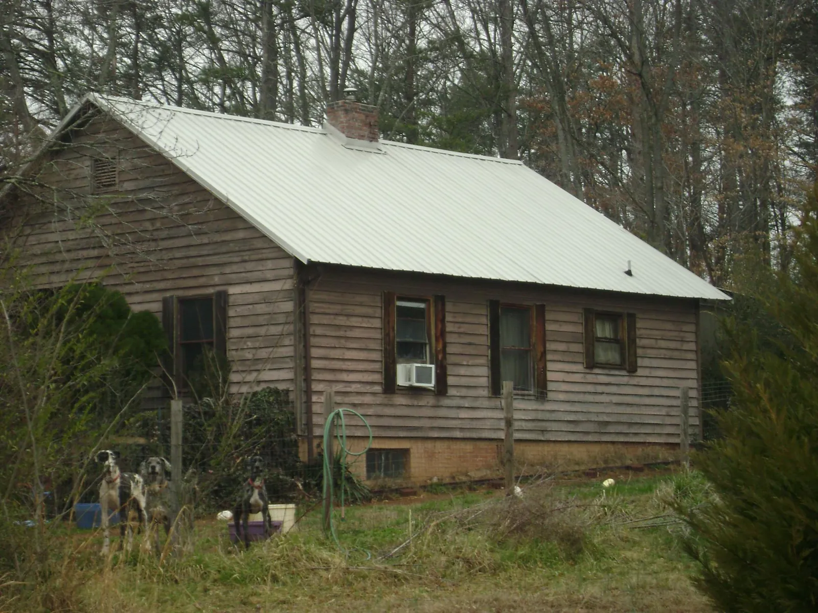 White metal roof on an old wood sided farmhouse, from a Asphalt Shingle Roof Repair job in New Enterprise